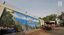 Anak-anak bermain di sekitar mural Betawi di Kampung Pitung, Marunda, Jakarta, Senin (2/7). Mural yang dibuat sejak sebulan lalu ini merupakan goresan tangan warga lokal. (Merdeka.com/Iqbal S. Nugroho)