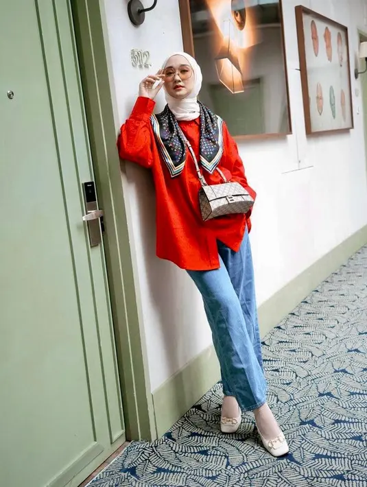 Celana jeans yang dipadukan dengan kemeja warna merah juga tak kalah menarik. Tambahan aksesori seperti scarf bikin tampilanmu makin stand out! (Instagram/dianpleangi).