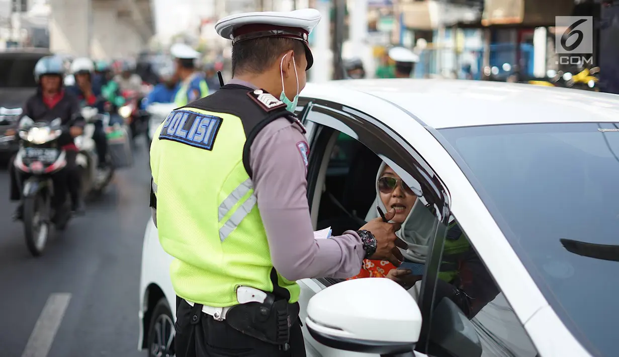 Petugas Kepolisian menindak pengendara mobil berplat nomor genap di persimpangan Jalan Dharmawangsa X dan Jalan Fatmawati, Jakarta, Senin (9/9/2019). Perluasan wilayah ganjil genap berlaku mulai hari ini dan terbagi di beberapa titik, salah satunya Jakarta Selatan. (Liputan6.com/Immanuel Antonius)