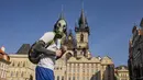 Seorang pria dengan masker gas berjalan melintasi Old Town Squaretempat kegiatan terhenti karena penyebaran virus corona baru di Praha pada 18 Maret 2020. Masker dijadikan masyarakat pilihan untuk mencegah penyebaran virus corona yang terus meningkat di seluruh dunia.  (Michal Cizek/AFP)