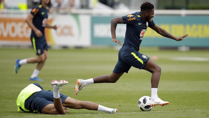 Ekspresi pemain Brasil, Fred (kanan) yang kesakitan setelah di jegal Casemiro pada sesi latihan di lapangan latihan Tottenham Hotspur football club, Inggris, (7/6/2018). Fred mengalami masalah di engkel kaki. (AP/Matt Dunham)