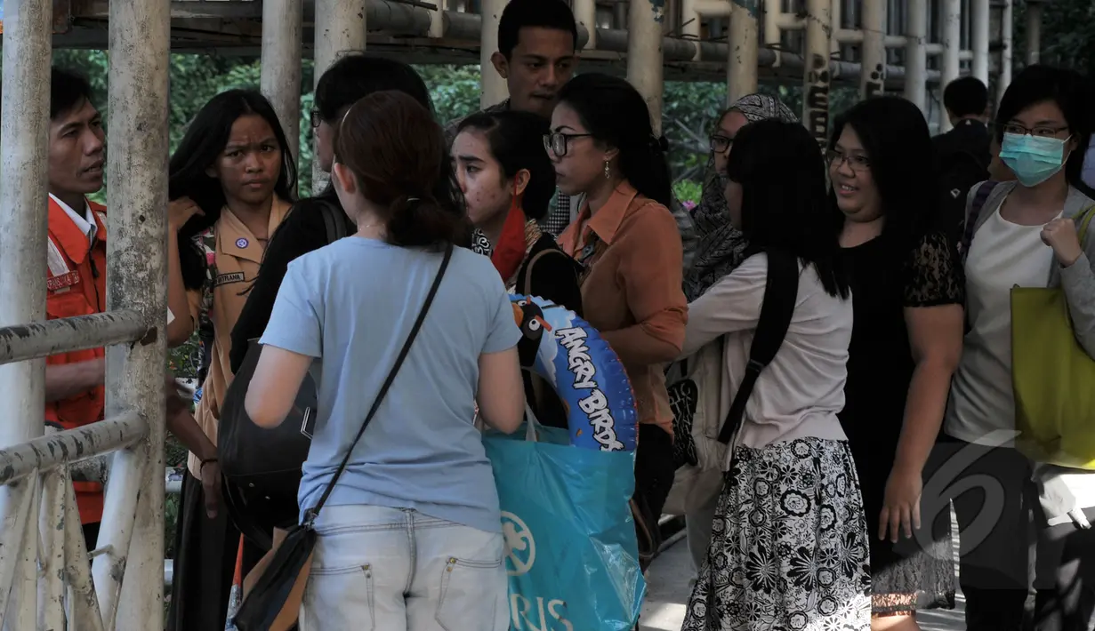 Petugas Transjakarta mencoba memberikan keterangan kepada para penumpang terkait penutupan sementara Rute Blok-M – Kota karena adanya pengalihan arus untuk kelancaran KAA, Jakarta, Rabu (22/4/2015) .(Liputan6.com/Johan Tallo)