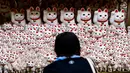 Pengunjung mengambil gambar patung-patung maneki-neko di Kuil Gotokuji, Tokyo, Jepang, Rabu (10/6/2020). Kuil Gotokuji terkenal karena dipercaya sebagai tempat kelahiran maneki-neko, kucing pembawa keberuntungan. (Philip FONG/AFP)