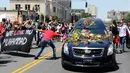 Seorang pria mengulurkan tangan untuk menyentuh mobil jenazah yang membawa jasad mantan petinju dunia, Muhammad Ali saat akan dimakamkan di Louisville, Kentucky, AS, 10 Juni 2016. (REUTERS / Adrees Latif)