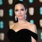 Aktris Angelina Jolie berpose saat tiba di BAFTA Awards 2018 di London, Inggris (18/2). Angelina tampil cantik dan seksi mengenakan gaun berwarna hitam dengan pundak terbuka. (Photo by Vianney Le Caer/Invision/AP)