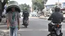 Pedagang tanpa mengenakan masker saat melintas di kawasan Pasar Minggu, Jakarta, Rabu (8/4/2020). Organisasi Kesehatan Dunia (WHO) telah merekomendasikan agar siapa saja menggunakan masker saat berada di tempat umum demi memutus mata rantai penyebaran virus Corona. (merdeka.com/Iqbal Nugroho)