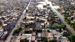 Pemandangan dari udara ini menunjukkan daerah pemukiman yang banjir setelah hujan lebat di provinsi Balochistan (29/8/2022). Jumlah korban tewas akibat banjir monsun di Pakistan sejak Juni telah mencapai 1.136, menurut angka yang dirilis pada 29 Agustus oleh Otoritas Manajemen Bencana Nasional negara itu. (AFP/Fida Hussain)