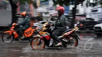 Para pengendara nekat melintasi jalan yang tergenang air. Sistem drainase yang buruk menjadi penyebab banjir di sejumlah ruas jalan di Ibu Kota selalu, Jakarta, Kamis (22/1/2015).(Liputan6.com/Miftahul Hayat)