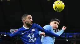 Gelandang Chelsea, Hakim Ziyech (kiri) bersaing dengan striker Manchester City Julian Alvarez (kanan) selama pertandingan putaran ketiga Piala FA Inggris di Stadion Etihad di Manchester, Inggris, pada 8 Januari 2023. Penawaran PSG sudah diterima pihak Chelsea dan Ziyech. Mantan pemain Ajax ini kemudian menjalani tes medis di Paris dengan sukses. (Oli SCARFF / AFP)