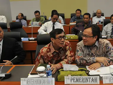 Menteri Hukum dan Ham Yasonna Laoly (tengah), bersama Menteri Keuangan Bambang Brodjonegoro (kanan) berbincang saat mengikuti rapat kerja dengan Banggar DPR, Jakarta, (29/10/2015). Rapat juga membahas RUU APBN TA 2016. (Liputan6.com/Johan Tallo)