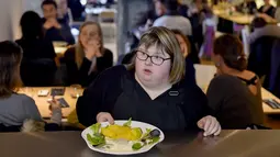 Seorang pelayan dengan down syndrome bersiap mengantar pesanan kepada pengunjung restoran "Le Reflet" di Nantes, Prancis Barat, 9 Februari 2017. Lelievre (26), mempekerjakan sejumlah karyawan yang memiliki down syndrome di restorannya. (LOIC VENANCE/AFP)