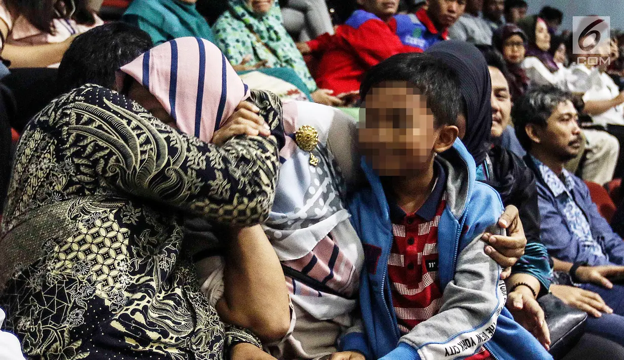 Ekspresi terpidana kasus dugaan pelanggaran UU ITE sekaligus korban pelecehan seksual Baiq Nuril saat DPR menyetujui amnesti untuk dirinya dalam rapat paripurna DPR di Kompleks Parlemen Senayan, Jakarta, Kamis (25/7/2019). (Liputan6.com/JohanTallo)