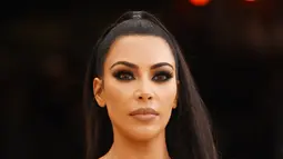 Aktris Kim Kardashian menghadiri Met Gala 2018 untuk pembukaan "Heavenly Bodies: Fashion and The Catholic Imagination" di Manhattan, New York, Amerika Serikat, (7/5). Kim Kardashian tampil seksi mengenakan gaun emas super ketat. (AFP Photo/Jamie McCarthy)