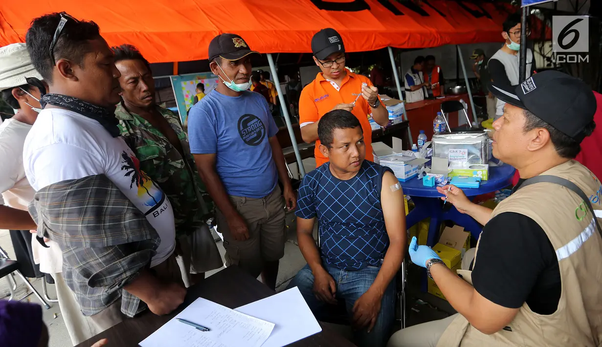 Petugas bio farma berbincang dengan warga korban gempa di kantor Dinkes Palu, Sulawesi Tengah, Minggu (7/10). Kemenkes dan Bio Farma mengirimkan 7 petugas medis yang akan bekerja selama 9 hari. (Liputan6.com/Fery Pradolo)