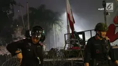 Bendera Merah Putih terbalik akibat kericuhan antara massa aksi dengan personil kepolisian yang berusaha menghalau massa yang berlaku anarkis di sekitar Gedung Bawaslu, Jalan MH Thamrin, Jakarta, Rabu (22/5/2019). Aksi unjuk rasa yang dimotori GNKR berakhir ricuh. (Liputan6.com/Helmi Fithriansyah)