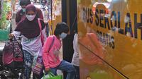 Sejumlah pasien Covid-19 Tanpa Gejala saat memasuki bus sekolah di Puskesmas Kecamatan Cilandak, Jakarta, Kamis (4/2/2021). Data Satgas Covid-19 per Kamis (4/2) mencatat kasus positif di Indonesia bertambah 11.434 orang. (Liputan6.com/Herman Zakharia)