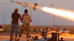 Para pasukan Libya yang berkoalisi dengan PBB melihat roket yang ditembakan ke arah pasukan ISIS saat bertempur di Sirte, Libya, (4/8). (REUTERS/Goran Tomasevic)