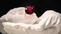 Perwakilan dari Sotheby's mengangkat Estrela de Fura Ruby, batu rubi terbesar di dunia, di Hong Kong pada 17 April 2023. (Photo by Peter PARKS / AFP)