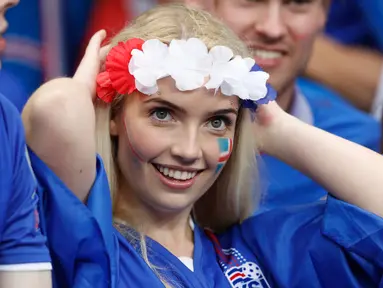 Seorang suporter timnas Islandia tersenyum mengunakan atribut di kepalanya saat menghadiri pertandingan antara Islandia melawan timnas Perancis dalam Perempat Final Piala Eropa 2016 di Stade de France, Prancis, (3/7).  (Reuters/Carl Recine)