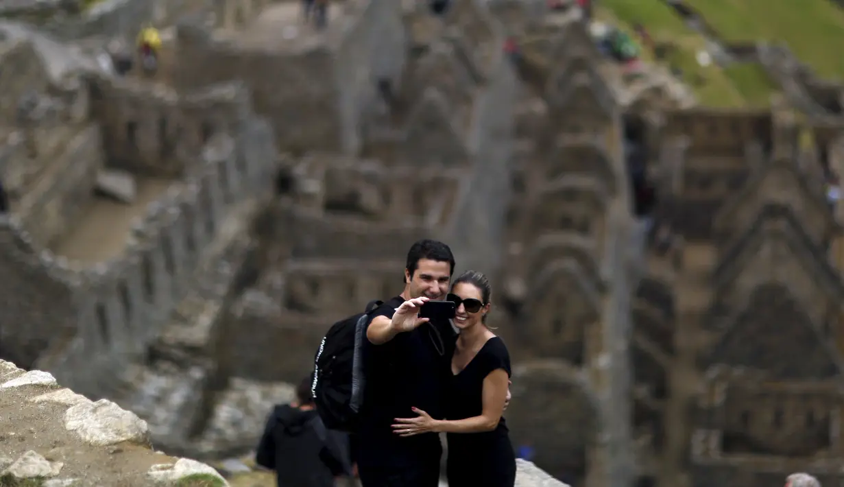 Pasangan wisatawan berselfie di reruntuhan kerajaan inca di pegunungan Machu Picchu , Peru, Rabu (12/8/2015).  Pemerintah setempat membatasi wisatawan yang masuk ke Machu Picchu yang hanya menerima 2.500 wisatawan. (REUTERS/Pilar Olivares)