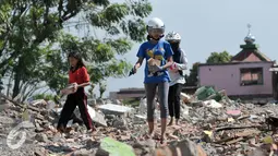 Sejumlah warga mengumpulkan batu bata merah dari sisa puing-puing rumah pembongkaran di Bukit Duri, Jakarta, Kamis (29/9). Batu bata merah yang dikumpulkan akan kembali dijual oleh warga dengan harga yang sangat murah. (Liputan6.com/Yoppy Renato)