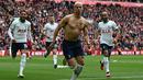 Pemain Tottenham Hotspur, Richarlison melakukan selebrasi dengan melepas jersey setelah mencetak gol penyeimbang ke gawang Liverpool di tambahan waktu babak kedua dalam pertandingan lanjutan English Premier League 2022/2023 yang berlangsung di Anfield stadium, Minggu (30/4/2023). (AFP/Paul Ellis)