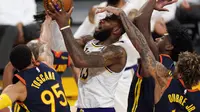 Bintang Los Angeles Lakers, LeBron James, saat berusaha menembak bola di tengah kepungan pemain Golden State Warriors, Senin (1/3/2021) pagi WIB. (AP Photo/Mark J. Terrill)