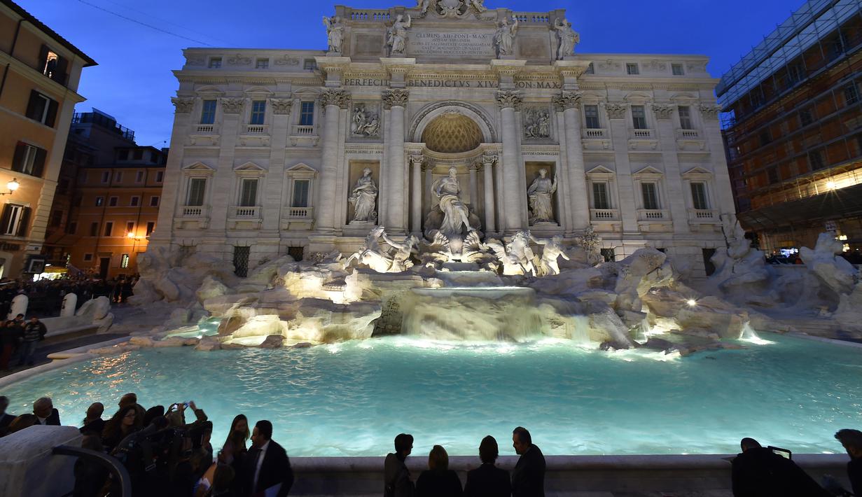 Pengunjung mengabadikan gambar air mancur Trevi Fountain saat peresmiannya setelah ditutup untuk renovasi, Roma, Selasa (3/11). Renovasi digagas oleh salah satu brand fashion Italia, Fendi, dengan biaya 2,2 juta Euro (Rp 32 m). (AFP PHOTO/ALBERTO PIZZOLI)