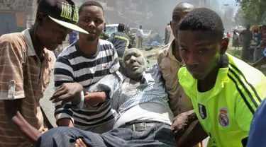 Sejumlah orang membawa pria yang terkena akibat serangan bom mobil di Mogadishu, Somalia, Senin (13/3). Sebuah mobil meledak di dekat Hotel Weheliye dan menewaskan sejumlah orang. (AP Photo / Farah Abdi Warsameh)