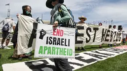 Pengunjuk rasa menolak kehadiran Isaac Herzog karena kebijakan Israel di Gaza. Tampak dalam foto, para pengunjuk rasa berkumpul di depan gedung Parlemen menjelang pertemuan antara Perdana Menteri Australia Anthony Albanese dan Presiden Israel Isaac Herzog di Canberra pada Rabu 11 Februari 2026. (David GRAY/AFP)