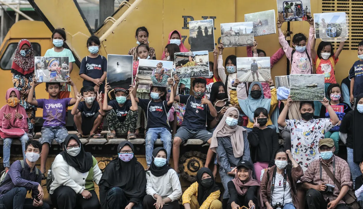 Anak-anak berfoto bersama saat Kelas Jurnalis Cilik di Cilincing, Jakarta, Minggu (6/6/2021). Selama 4 bulan mereka akan menggali identitasnya sebelum karya visual mereka menyingkap pesan di hadapan publik. (merdeka.com/Iqbal S Nugroho)