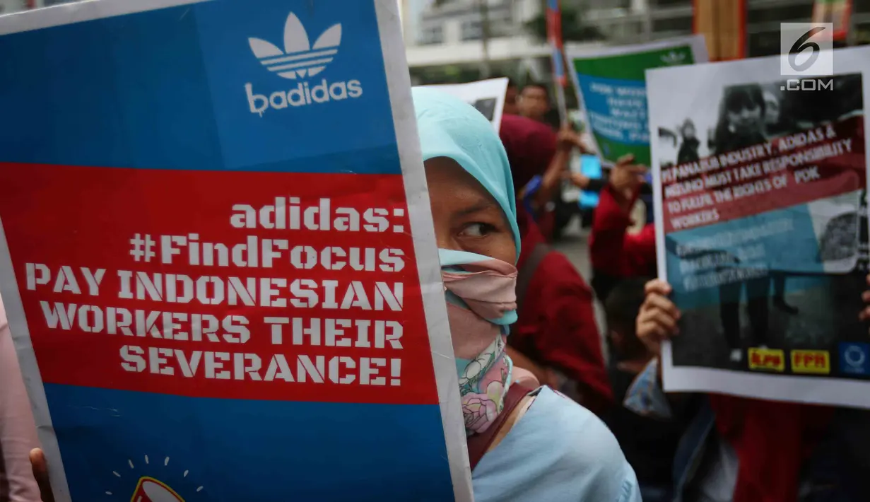 Seorang buruh membawa poster saat melakukan aksi di depan Kedubes Jerman di Jakarta, Selasa (18/7). Dalam aksi itu mereka menuntut Kedubes Jerman untuk membantu menyelesaikan permasalahan yang terjadi pada PT Panarub Dwikarya. (Liputan6.com/Angga Yuniar)