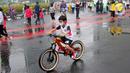 Seorang anak mengendarai sepeda saat CFD di kawasan Bundaran HI, Jakarta, Minggu (3/7/2022). Meski sempat diguyur hujan tidak menyurutkan  masyarak untuk berolahraga di akhir pekan. (Liputan6.com/Angga Yuniar)