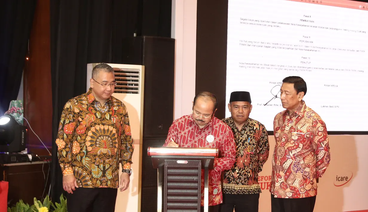 Ketua Umum Ikatan Sarjana Hukum Indonesia (ISHI) Amzulian Rifai (dua kiri) didampingi Menko Polhukam Wiranto (kanan) menandatangani MoU saat pengukuhan PP ISHI di Kemenkumham, Jakarta, Senin (30/7). (Liputan6.com/Herman Zakharia)