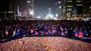 Sejumlah orang duduk di kapal kertas kuning yang didedikasikan untuk tragedi kapal feri Sewol selama unjuk rasa menuntut penggulingan Presiden Park Geun-hye pada malam pergantian tahun di Seoul, Korea Selatan (Korsel), Sabtu (31/12). (REUTERS/Kim Hong-Ji)