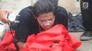 Jurnalis mengoleskan pasta gigi ke wajahnya saat demontrasi yang memanas di depan gedung DPR, Senayan, Jakarta, Selasa (24/9/2019). Polisi menembakkan gas air mata dan meriam air untuk membubarkan massa aksi yang menolak RKUHP dan RUU kontroversial lain. (merdeka.com/Arie Basuki)