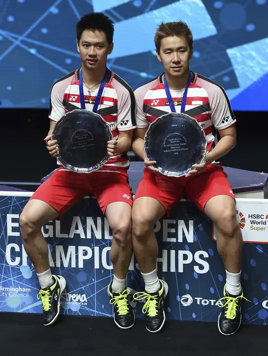 Ganda putra Indonesia, Kevin Sanjaya dan Marcus Gideon merayakan gelar All England di Birmingham, Minggu (18/3/2018). Mereka juara setelah mengalahkan Mathias Boe dan Carsten Mogensen dengan skor 21-18, 21-17. (AFP/Paul Ellis)