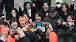 Anggota parlemen Korea Selatan Han Jeong-ae (tengah) merayakan dengan para aktivis hak-hak hewan dalam sebuah unjuk rasa menyambut rancangan undang-undang yang melarang perdagangan daging anjing di Majelis Nasional di Seoul pada tanggal 9 Januari 2024. (Jung Yeon-je/AFP)