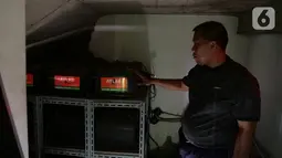 Petugas sekolah mengecek baterai penyimpan tenaga listrik yang tersambung dengan panel surya di SMPN 1 Jakarta, Kamis (3/10/2019). Sekitar 100 sekolah di DKI Jakarta telah dipasangi atau panel surya (solar panel) yang bertujuan memperbaiki kualitas udara di Jakarta. (Liputan6.com/Herman Zakharia)