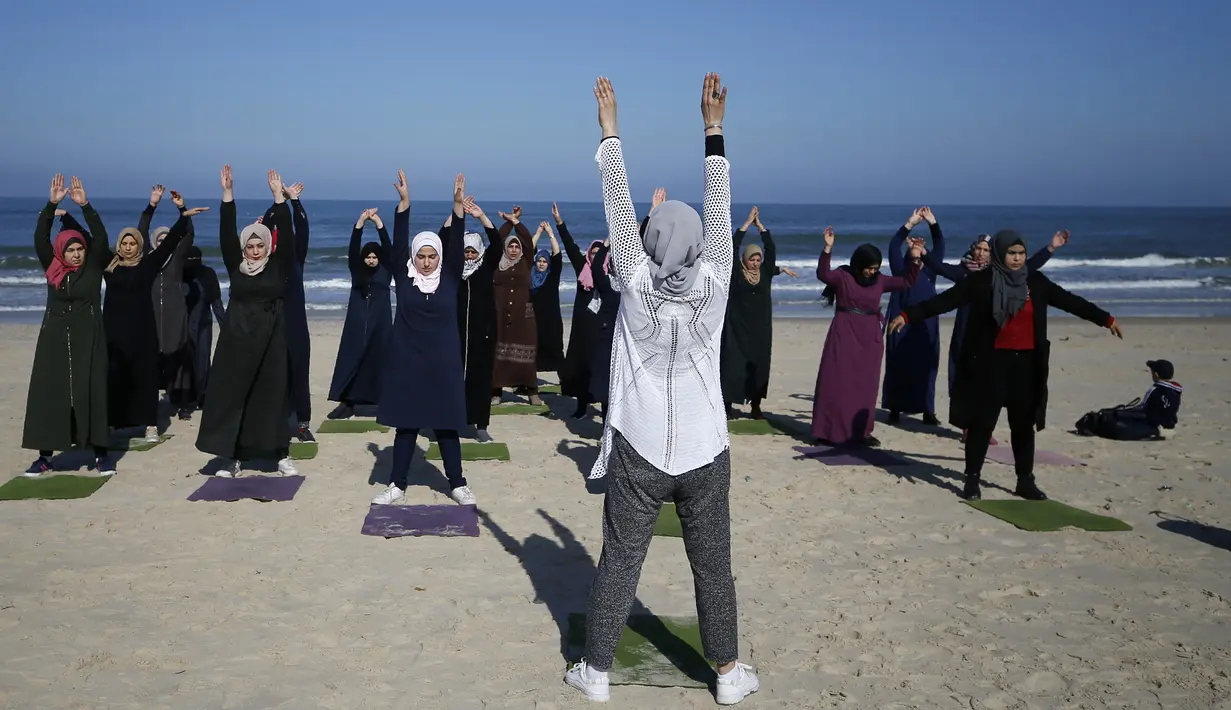 Sejumlah wanita Palestina berlatih yoga di pantai di Gaza City (3/3/2020). Pelatihan yoga tersebut diselenggarakan oleh Positive Energy Club. (AFP Photo/Mohammed Abed)