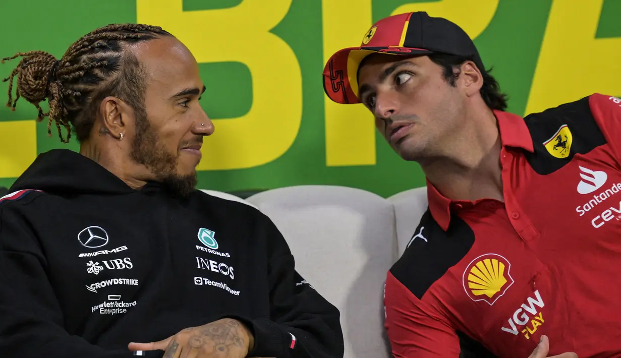 <p>Pembalap Mercedes, Lewis Hamilton (kiri) tersenyum ke arah pembalap Ferrari, Carlos Sainz saat konferensi pers Formula 1 GP Brasil di Sirkuit Jose Carlos Pace, Sao Paulo, Brasil, 2 November 2023. (AFP/Nelson Almeida)</p>