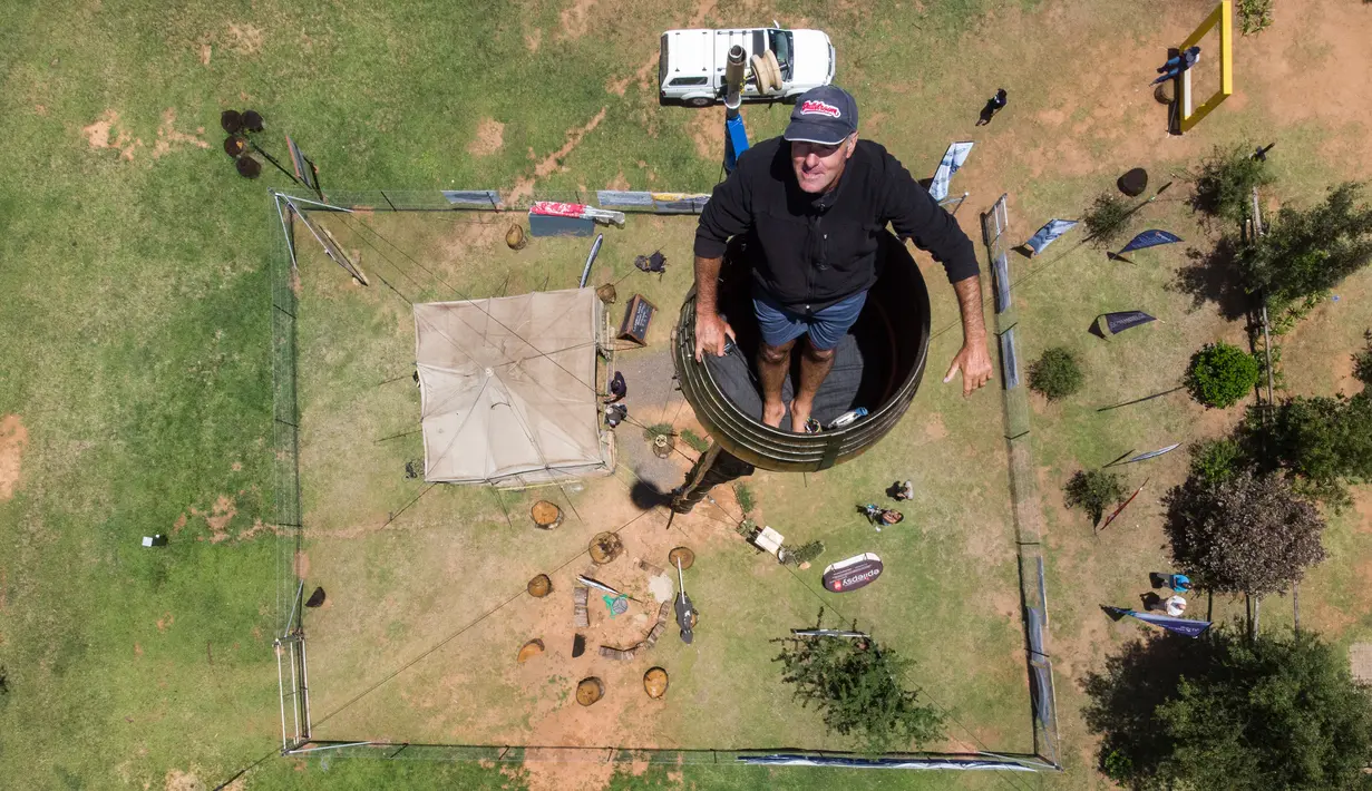 Pandangan aerial memperlihatkan Vernon Kruger, 52, berdiri dalam tong di atas tiang dengan ketinggian 25 meter di Dullstroom, Afrika Selatan, 16 Januari 2020. Kruger telah menghabiskan 67 hari di dalam tong dan masih menolak untuk turun padahal rekor telah dipecahkannya. (ANTOINE DEMAISON/AFP)