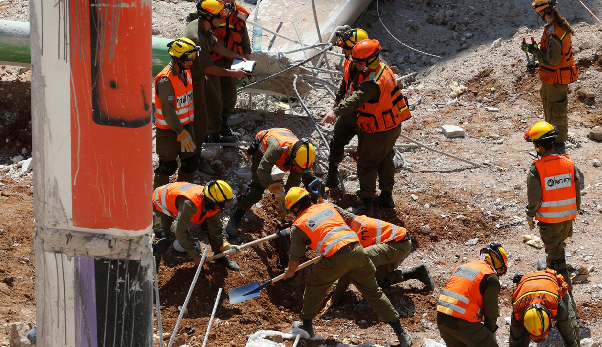 Petugas penyelamat mencari korban dengan menggali reruntuhan ambruknya gedung parkir yang sedang dibangun di Tel Aviv, Israel, Senin (5/9). Sebanyak 15 orang terjebak dalam reruntuhan tersebut. (REUTERS/Nir Elias)