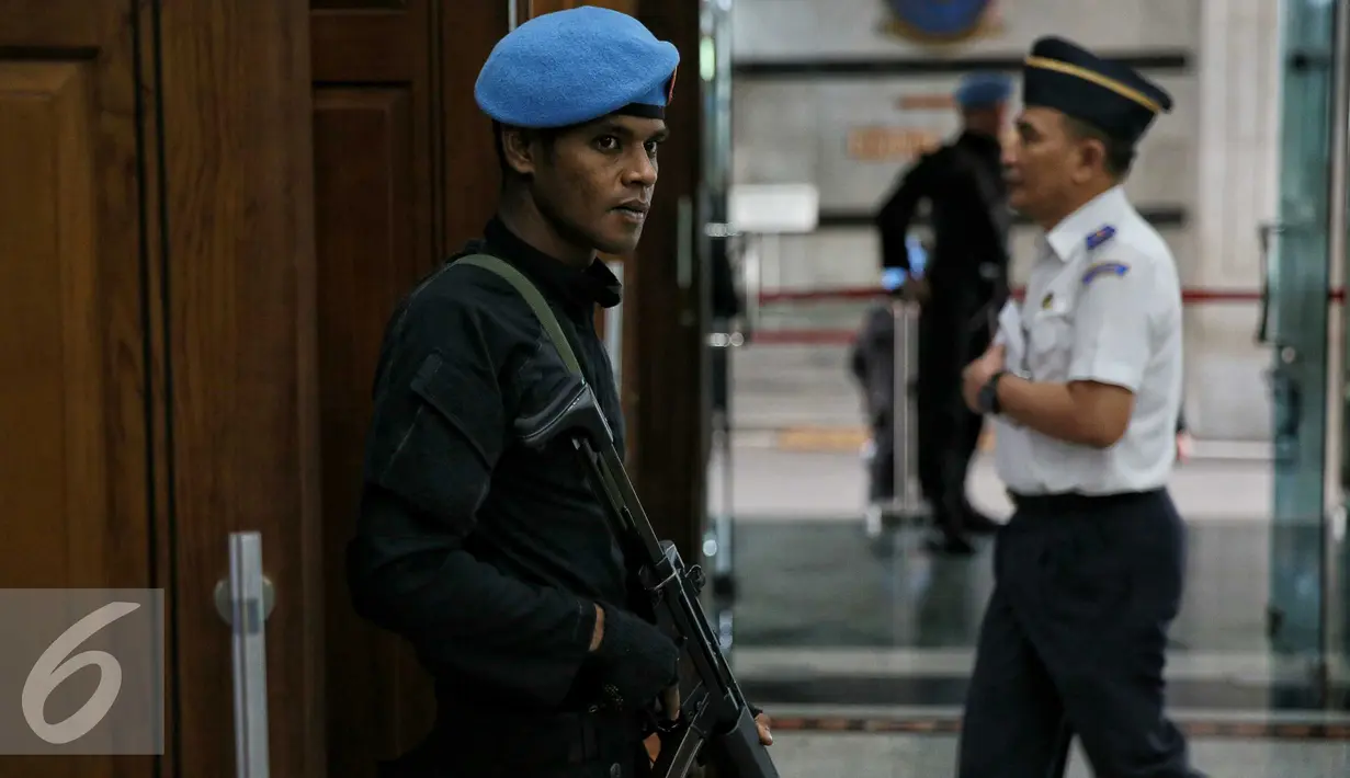 Petugas paspampres dengan senjata lengkap berjaga didepan pintu pada acara yang dihadiri Presiden, di Jakarta, Senin (18/1). Pengamanan ketat terhadap Presiden dilakukan pasca teror bom pada Kamis (14/1) dikawasan MH.Thamrin. (Liputan6.com/Faizal Fanani)