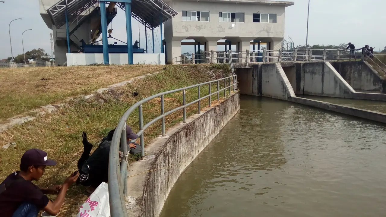 Beberapa pemancing warga lokal menggunakan pintu air Bendungan Cimanuk Garut, Jawa Barat, untuk kegiatan mancing saat ngabuburit tiba