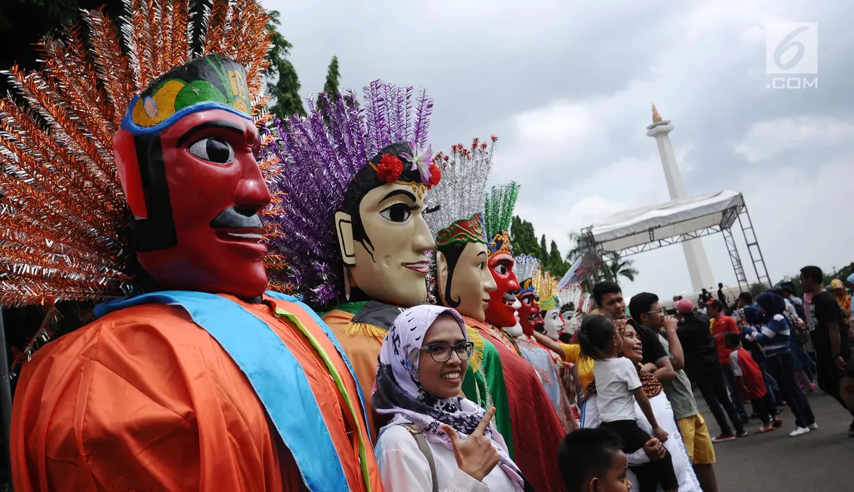 Deretan ondel-ondel berjajar di kawasan silang Monumen Nasional, Jakarta, Minggu (26/11). Deretan ondel-ondel ini bagian kemeriahan Kirab Kebangsaan yang diadakan Bamus Betawi. (Liputan6.com/Helmi Fithriansyah)