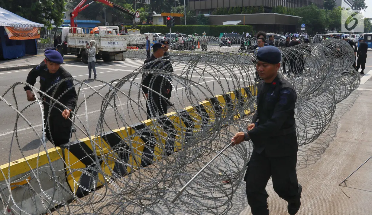 Personel korps Brimob membentangkan kawat berduri di kawasan Kantor Bawaslu, Jakarta, Selasa (21/5/2019). Personel TNI-Polri dari berbagai kesatuan disebar ke sejumlah titik dan objek vital guna membantu pengamanan Ibu Kota setelah penetapan hasil rekapitulasi suara Pilpres 2019. (Liputan6.com/Johan