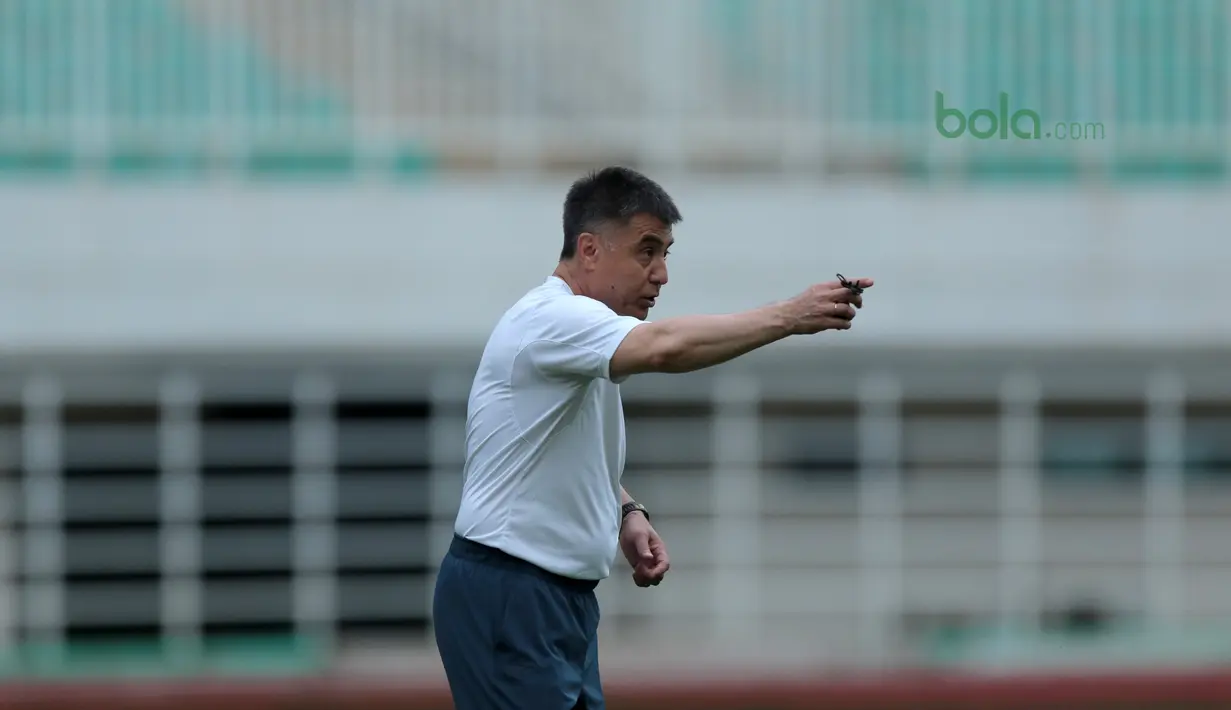 Pelatih Uzbekistan, Ravshan Khaydarov  memberikan instruksi pada uji coba lapangan di Stadion Pakansari, Bogor, (26/4/2018). Uzbekistan merupakan salah satu tim yang akan mengikuti ajang PSSI Anniversarry Cup 2018. (Bola.com/Nick Hanoatubun)
