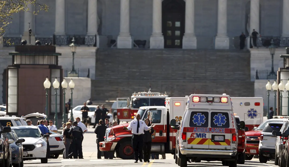 Mobil ambulans dan kendaraan darurat disiagakan di depan Gedung Capitol, Washington DC, Amerika Serikat, pascapenembakan di lokasi tersebut, Senin (28/3). Sempat terjadi tembak-menembak dengan petugas sebelum pelaku dilumpuhkan. (REUTERS/Joshua Roberts)