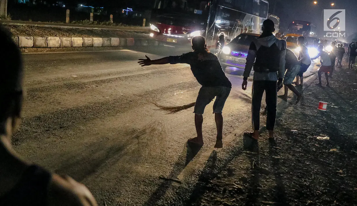 Sejumlah penyapu koin kali Sewo menunggu uang yang dilemparkan oleh pengguna jalan yang melintasi Jembatan Sewo, Kabupaten Indramayu, Jawa Barat, Minggu (2/7). (Liputan6.com/Faizal Fanani)